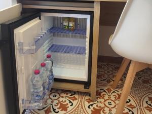 un frigorifero aperto con bottiglie d'acqua di Luma casa Vacanze Cefalù a Cefalù Altre 17 foto