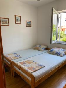 a bedroom with two beds and a window at Apartment Sun in Novalja