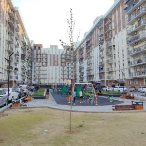 a playground in front of a large apartment building at parkent plaza apartments in Tashkent