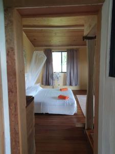 1 dormitorio con 1 cama blanca grande y ventana en Casa Cereza, en Tierra Oscura