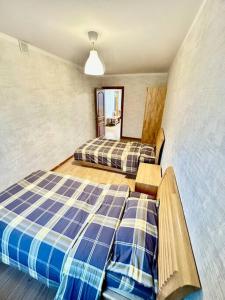 a bedroom with two beds and a mirror at 6 guest family apartment in Ulaanbaatar