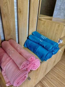 a wooden cabinet with some pink and blue towels at 6 guest family apartment in Ulaanbaatar