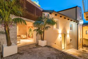 陶爾米納的住宿－Taormina Infinity Suites，两棵棕榈树在房子前面