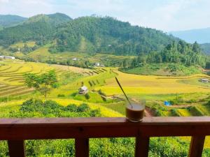 een drankje op een tafel met uitzicht op een veld bij Hill home Hoang Su Phi in Nam Pi