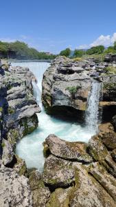 a waterfall on the side of a river with rocks at Apartmani Stari Aerodrom in Podgorica