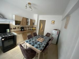 a kitchen with a table and chairs in a room at Apartament Costescu in Băile Herculane