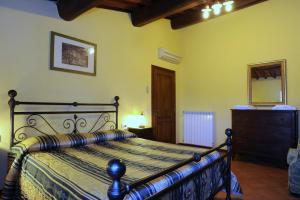 a bedroom with a bed and a dresser and a mirror at Erboli Residence in Cavriglia