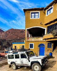 une jeep blanche garée devant un bâtiment dans l'établissement Gîte d’étape Chrifi, à Anergui