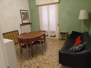- un salon avec une table en bois et un canapé dans l'établissement Rubino 8, à Parme