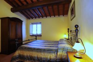 a bedroom with a bed and a table with a lamp at Erboli Residence in Cavriglia
