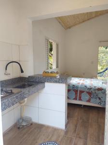 una cocina con fregadero y una cama en una habitación en CHALÉS MARICOTA, en Vargem Bonita