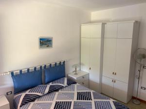 1 dormitorio con 1 cama y armario blanco en A pochi passi dal mare, con giardino privato - A few meters from the sea, with private garden en Stintino
