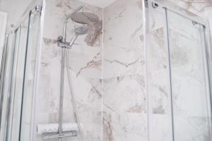 um chuveiro na casa de banho com uma parede em mármore em Castle Varagh Hotel & Bar em Westmeath