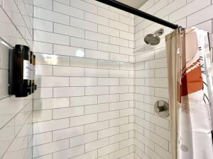 印第安納波利斯的住宿－Modern Style Home Near DT Indy & Major Attractions，浴室设有白色地铁瓷砖和淋浴。