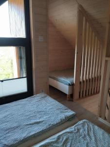 ein kleines Zimmer mit 2 Betten und einem Fenster in der Unterkunft Klimatyzowany domek letniskowy in Mielno