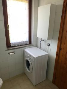 a washing machine in a bathroom with a window at A pochi passi dal mare, con giardino privato - A few meters from the sea, with private garden in Stintino