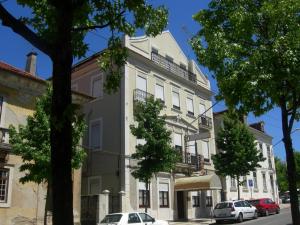 a large building with a clock on the side of it at Residencial Antunes in Coimbra