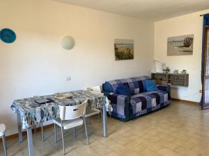 a living room with a table and a couch at A pochi passi dal mare, con giardino privato - A few meters from the sea, with private garden in Stintino