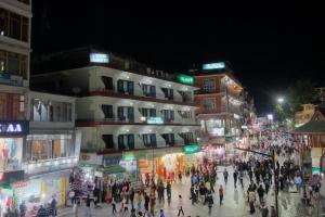 a group of people walking down a street at night at Hotel Highway Inn Manali - Luxury Stay - Excellent Service - Parking Facilities in Manāli