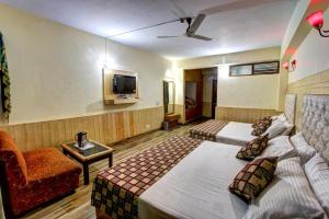 a hotel room with two beds and a couch at Hotel Highway Inn Manali - Luxury Stay - Excellent Service - Parking Facilities in Manāli