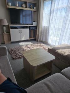 een woonkamer met een bank en een salontafel bij Jenny,s place in Saint Osyth