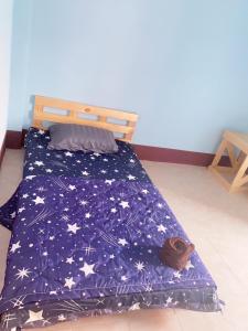 a bed with a blue comforter with stars on it at CTM.INN (SISAKET)THAILAND 