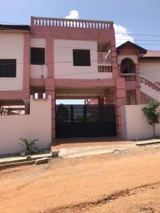 a house with a gate in front of it at Nyawoyi villa in Tokuse