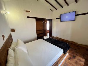 Camera con letto e TV a parete. di cabaña las mariposas Ecohotel a Villanueva