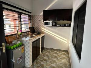 a small kitchen with a sink and a microwave at Nyawoyi villa in Tokuse
