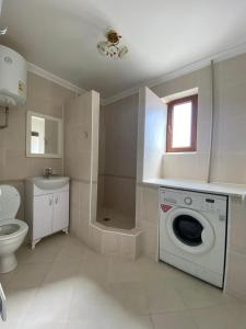 La salle de bains est pourvue d'un lave-linge et de toilettes. dans l'établissement Элитная 2-комнатная квартира в районе Болашак, à Kooperator