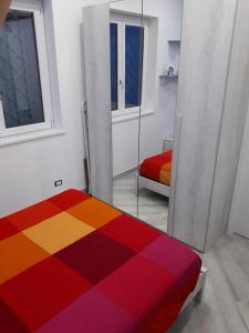 una camera con letto colorato e specchio di Villetta 28 (passi dal mare) ad Acquappesa