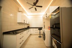 a kitchen with white cabinets and a ceiling fan at 5 Bedrooms Luxury Vacation Villa in Accra