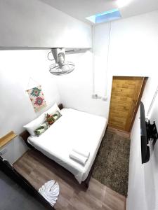 Un pequeño dormitorio con una cama blanca en una habitación en Hanuman VIP Hostel - SHA Plus en Bang Tao Beach