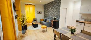 a living room with a blue couch and a kitchen at Appartements à thème in Clermont-Ferrand