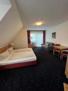 Habitación de hotel con cama y sofá en Hotel-Landpension Postwirt, en Kirchensittenbach