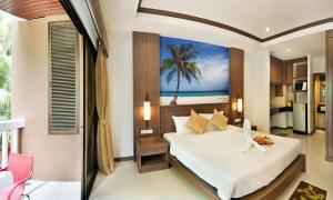 巴東海灘的住宿－Ratana Hill Patong，卧室配有一张床铺,墙上挂着棕榈树画