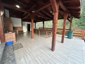 a pavilion with tables and benches on a wooden floor at Cabana de lângă Vale in Budureasa