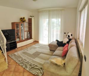 a living room with a couch with a stuffed panda bear on it at Villa DolceVita in Fregene