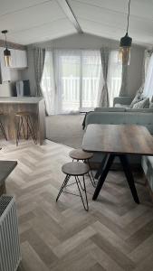 a living room with a table and a couch at T23- Pebble Bank Caravan Park in Weymouth
