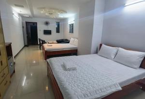 ein Schlafzimmer mit 2 Betten und ein Wohnzimmer in der Unterkunft KHÁCH SẠN Như Ý in Ho-Chi-Minh-Stadt