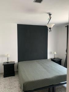 1 dormitorio con 1 cama con cabecero negro en Casa pajarera, en Fortuna