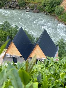 un grupo de casas con paneles solares en un río en Dereüstü ve Gökçe Bungalov - بنغل على ضفاف النهر, en Ardeşen