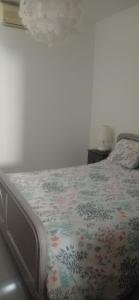 una camera da letto con un letto con copriletto floreale di Maison corse a Saparale