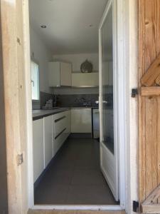 una cucina con armadi bianchi e una porta aperta di Maison corse a Saparale