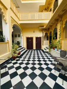 an empty courtyard of a building with a checkered floor at Hotel Mewari Villa in Udaipur