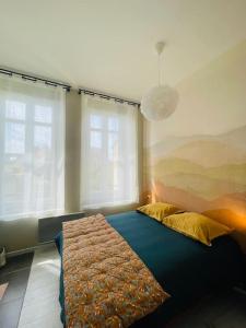 una camera da letto con un letto e due finestre di Emplacement idéal Confort et tranquillité a Boulogne-sur-Mer