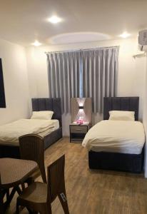 una camera d'albergo con due letti e un camino di Caprios motel a Al Qasţal