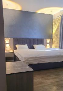 una camera da letto con un grande letto con due cuscini di Caprios motel a Al Qasţal