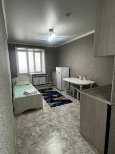 a room with a refrigerator and a table in it at Silk Way in Semey