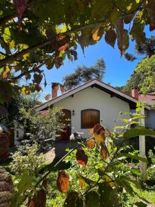 a house in the middle of a garden at Pousada Oliveri in Monte Verde